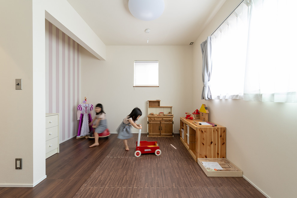 Inredning av ett flickrum för 4-10-åringar, med vita väggar, plywoodgolv och brunt golv