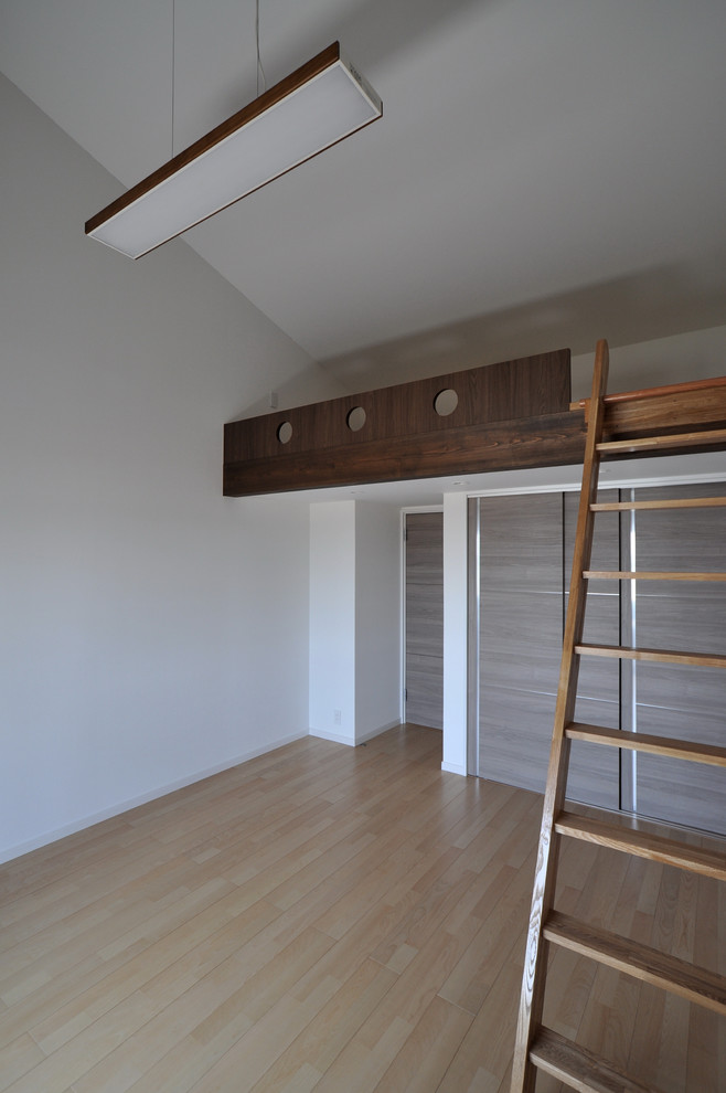 Exempel på ett könsneutralt barnrum kombinerat med lekrum och för 4-10-åringar, med vita väggar, plywoodgolv och brunt golv