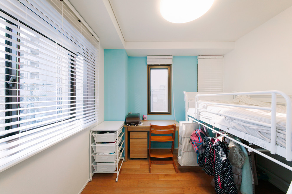Modelo de habitación infantil unisex de 4 a 10 años actual pequeña con paredes blancas y suelo de madera en tonos medios