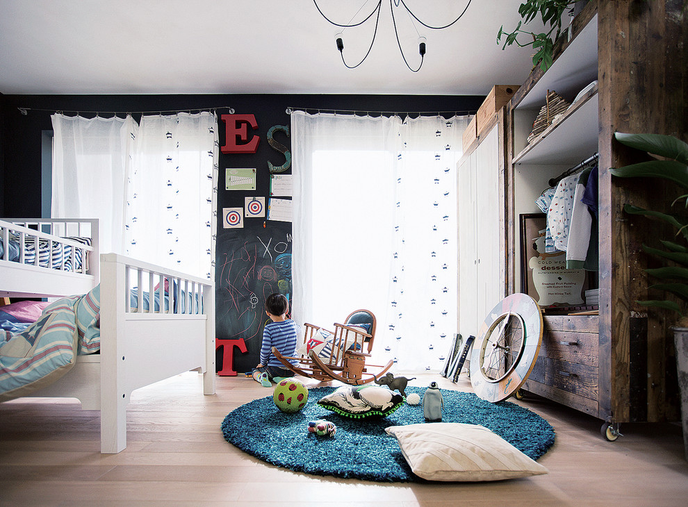 Rustic children’s room for boys in Tokyo with black walls and light hardwood flooring.