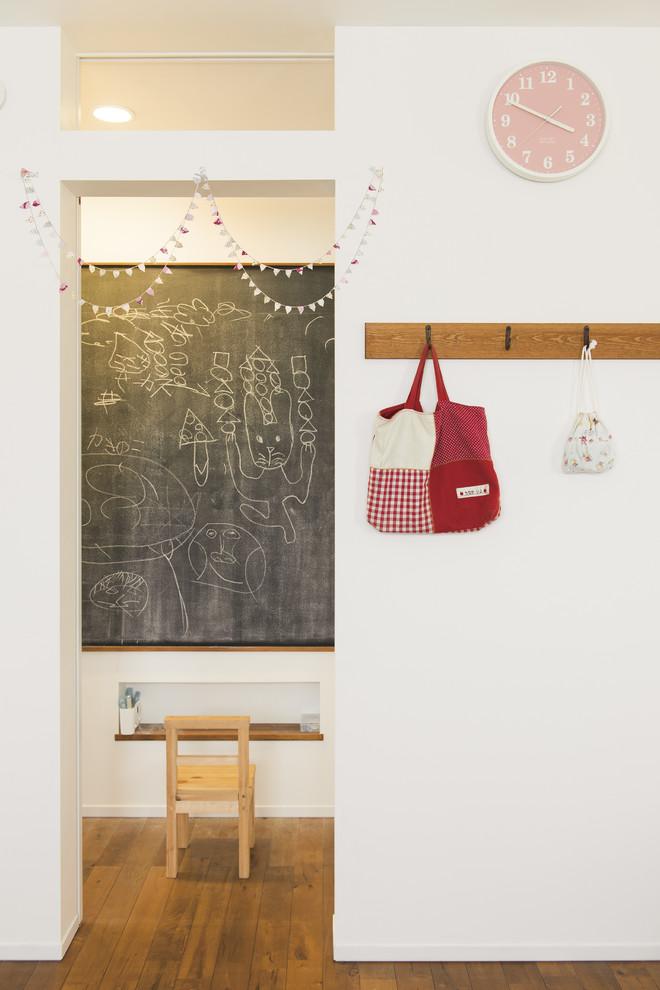 Modernes Mädchenzimmer mit Spielecke, weißer Wandfarbe und braunem Holzboden in Sonstige