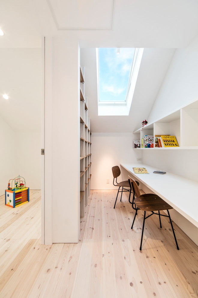 Cette photo montre une chambre d'enfant scandinave avec un mur blanc, parquet clair et un sol marron.
