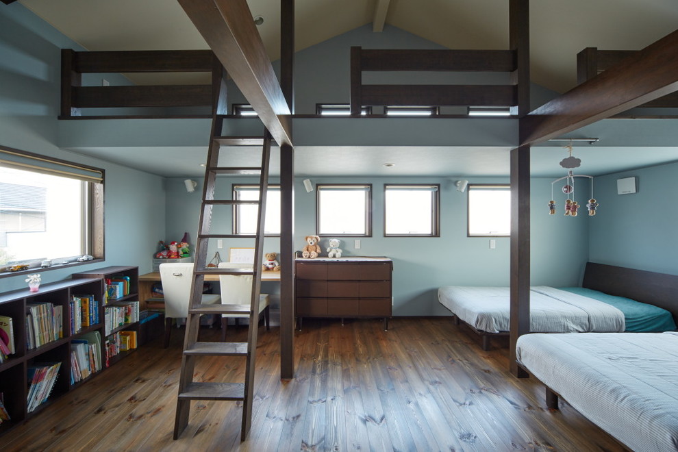 Exempel på ett modernt könsneutralt barnrum kombinerat med sovrum och för 4-10-åringar, med blå väggar och mellanmörkt trägolv