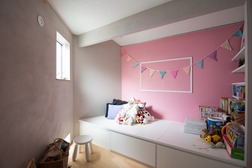 東京23区にあるおしゃれな遊び部屋 (ピンクの壁、白い床) の写真