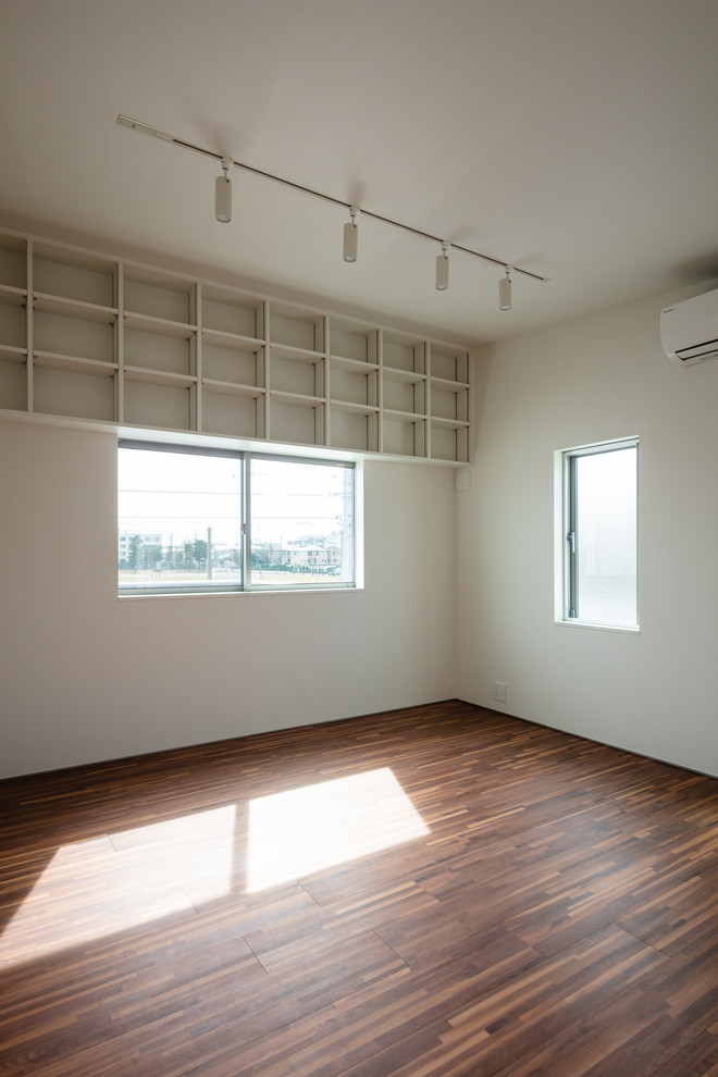 Bild på ett funkis flickrum, med vita väggar, plywoodgolv och brunt golv