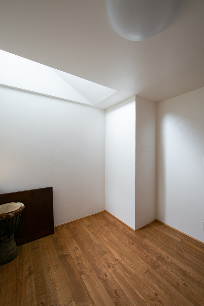 Bild på ett mellanstort funkis könsneutralt barnrum kombinerat med sovrum och för 4-10-åringar, med vita väggar, mellanmörkt trägolv och beiget golv
