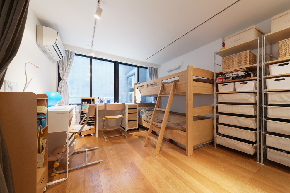 Ejemplo de habitación infantil unisex asiática con escritorio, paredes blancas, suelo de madera en tonos medios y suelo beige