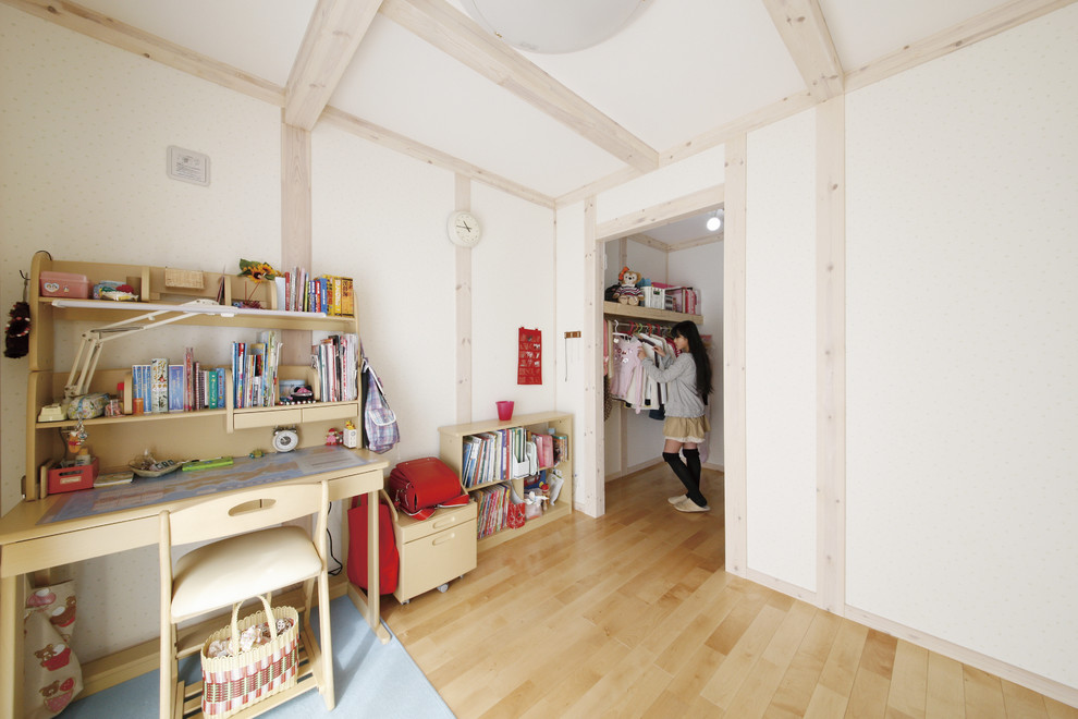 Idéer för barnrum, med vita väggar, mellanmörkt trägolv och beiget golv