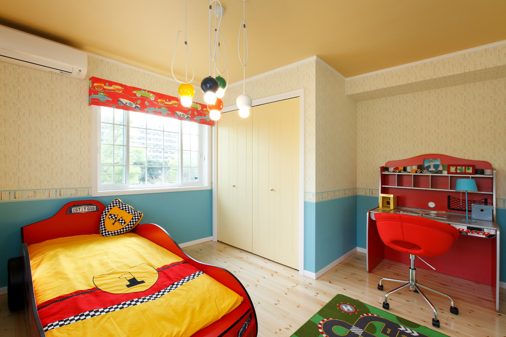Photo of a bohemian kids' bedroom with multi-coloured walls, light hardwood flooring and beige floors.