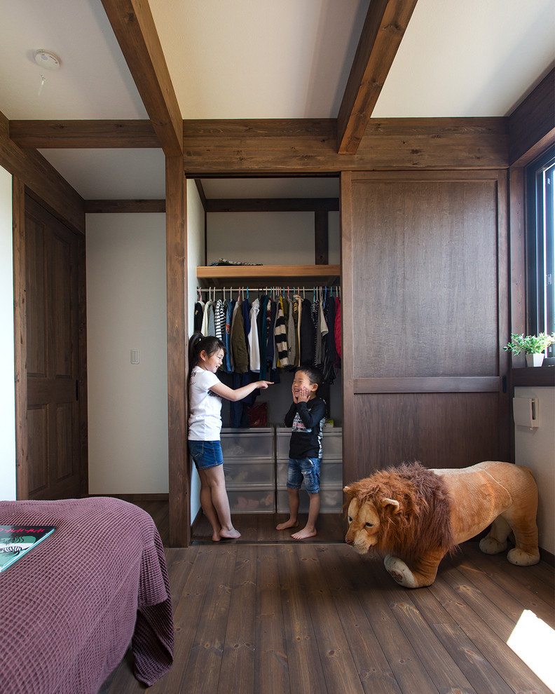 Design ideas for a world-inspired gender neutral kids' bedroom in Other with white walls, dark hardwood flooring and brown floors.