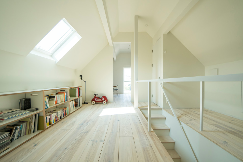 Bild på ett minimalistiskt barnrum, med vita väggar, målat trägolv och beiget golv