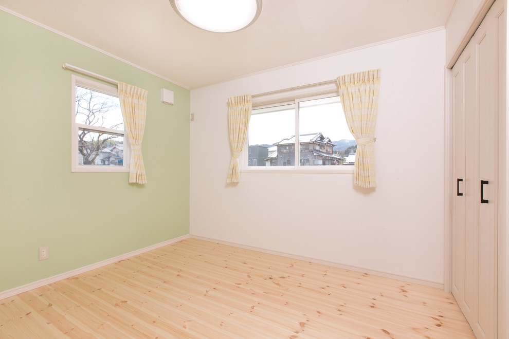 Idées déco pour une chambre d'enfant campagne avec un mur vert, un sol en bois brun et un sol beige.