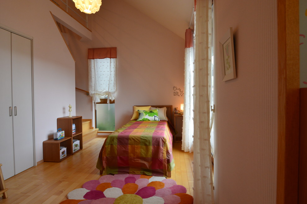 Esempio di una grande cameretta per bambini da 4 a 10 anni moderna con pareti rosa e parquet chiaro