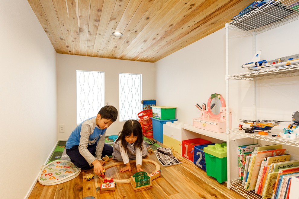 This is an example of a large industrial gender neutral kids' bedroom in Tokyo with light hardwood flooring, brown floors and white walls.
