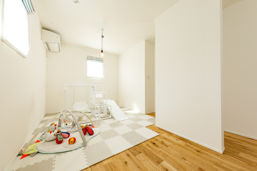 Immagine di una cameretta per bambini scandinava di medie dimensioni con pareti bianche, pavimento in legno massello medio, pavimento marrone, soffitto in carta da parati e pareti in perlinato
