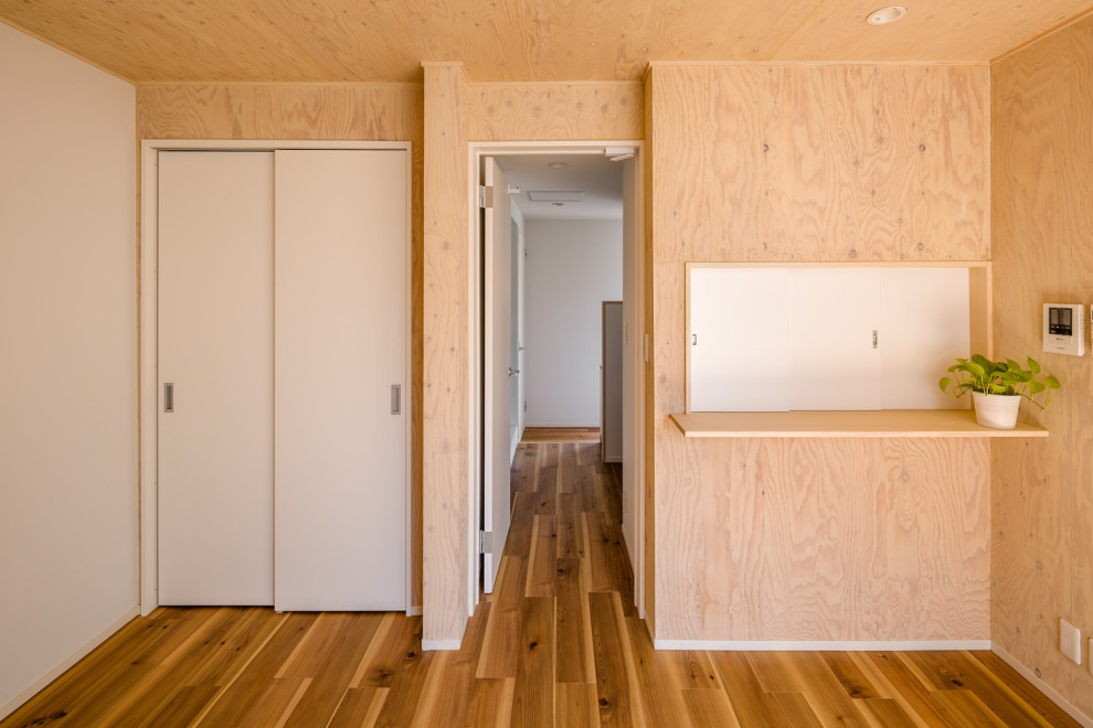 Idéer för mellanstora skandinaviska könsneutrala barnrum kombinerat med lekrum, med bruna väggar, mellanmörkt trägolv och brunt golv