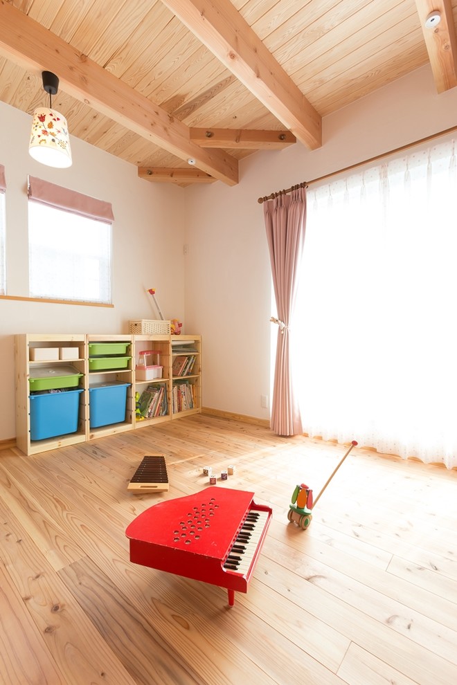 На фото: детская с игровой в восточном стиле с белыми стенами, светлым паркетным полом и коричневым полом с