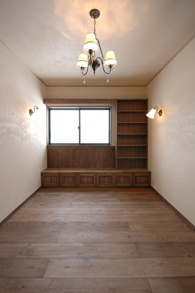 Immagine di una cameretta da bambina con pareti bianche, pavimento in compensato e pavimento marrone