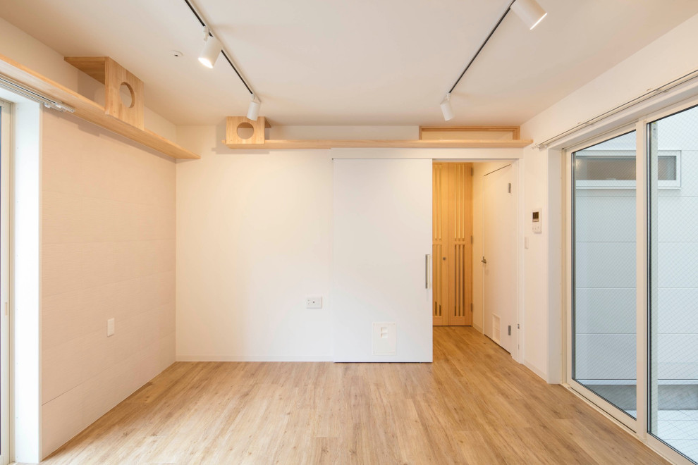 Example of a mid-sized danish gender-neutral light wood floor, beige floor, wallpaper ceiling and brick wall playroom design in Tokyo with white walls
