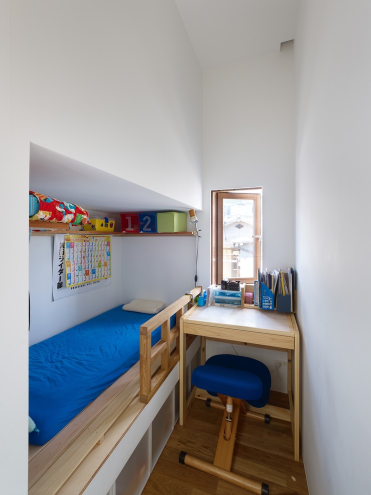 Photo of a small scandi children’s room for boys in Other with white walls and medium hardwood flooring.
