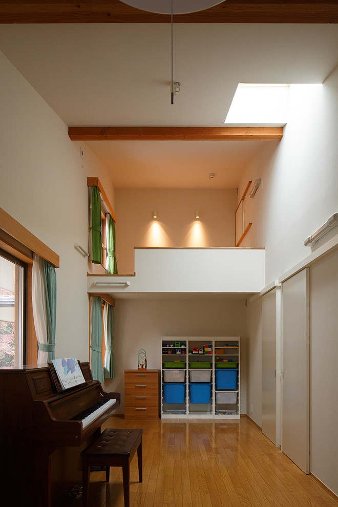 Cette image montre une chambre d'enfant de 4 à 10 ans asiatique de taille moyenne avec un mur blanc, un sol en bois brun et un sol marron.