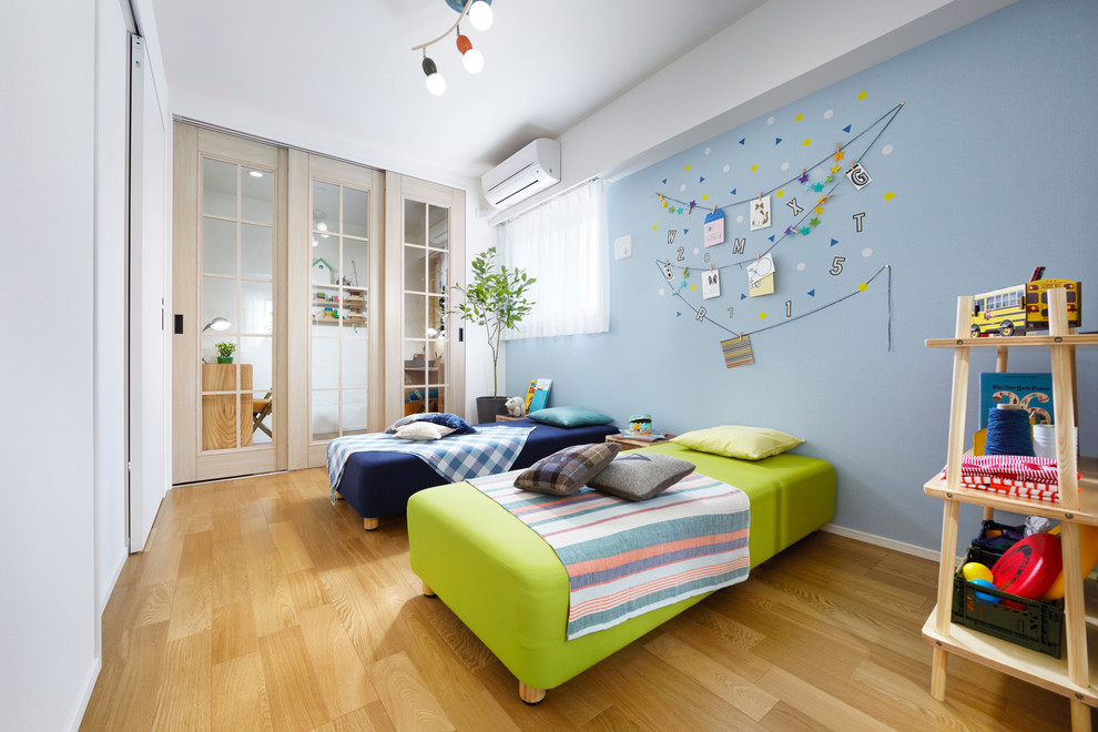 Imagen de dormitorio infantil de 4 a 10 años escandinavo con paredes azules y suelo de madera clara