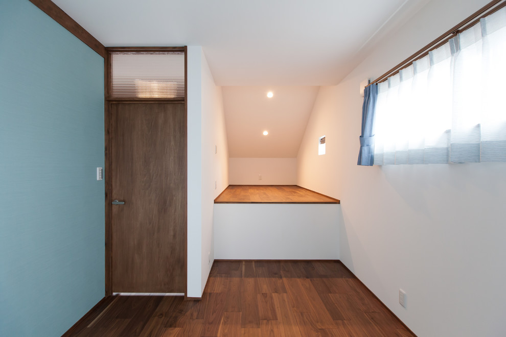 Réalisation d'une petite chambre neutre de 4 à 10 ans asiatique avec un bureau, un mur blanc, un sol en contreplaqué et un sol marron.