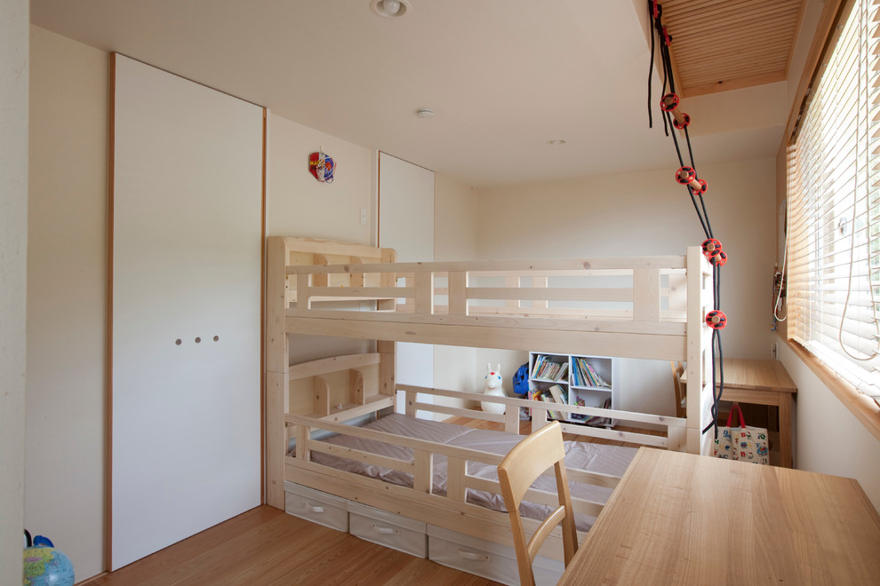 Réalisation d'une chambre neutre de 4 à 10 ans nordique avec un bureau, un mur blanc, un sol en bois brun et un lit superposé.
