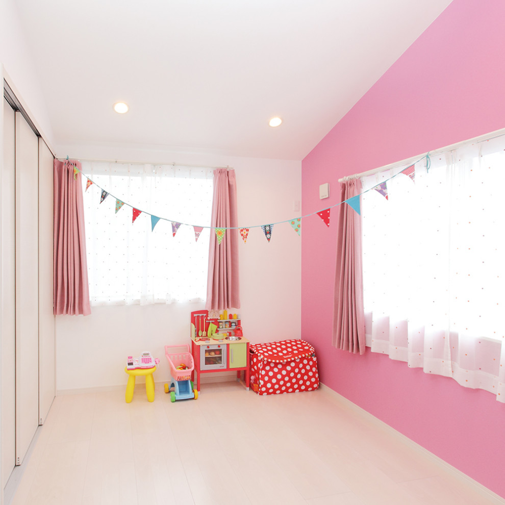 Esempio di una cameretta per bambini da 1 a 3 anni nordica con pareti rosa e pavimento bianco