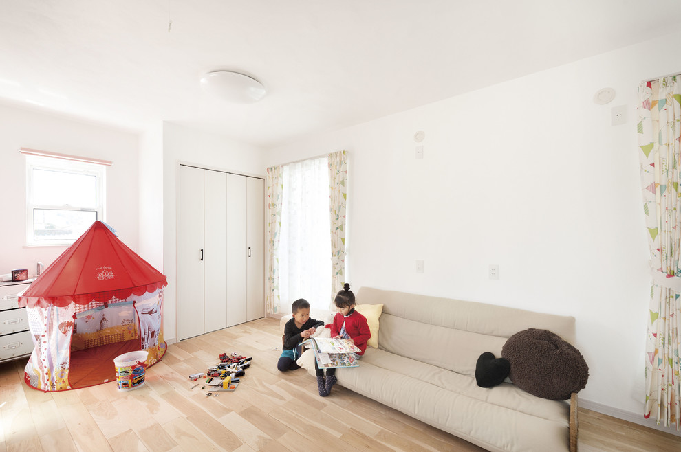 Neutrales Kinderzimmer mit Spielecke, weißer Wandfarbe, hellem Holzboden und rosa Boden in Sonstige