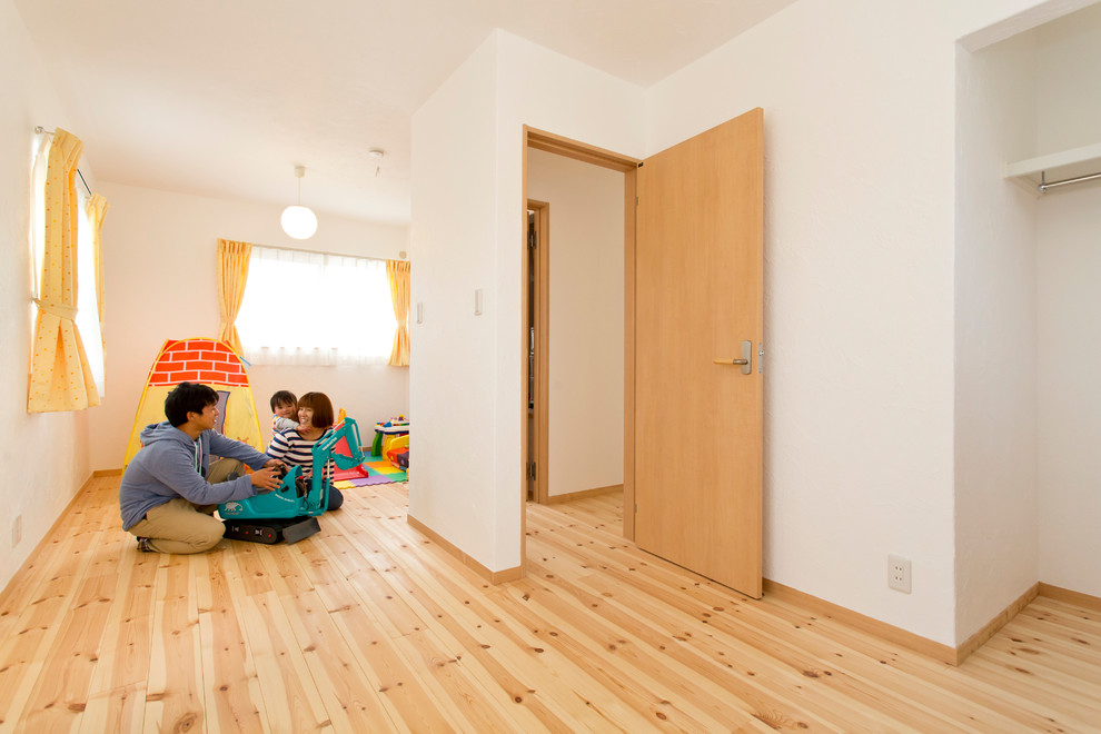 Ispirazione per una stanza dei giochi da 1 a 3 anni country con pareti bianche, pavimento in legno massello medio e pavimento beige