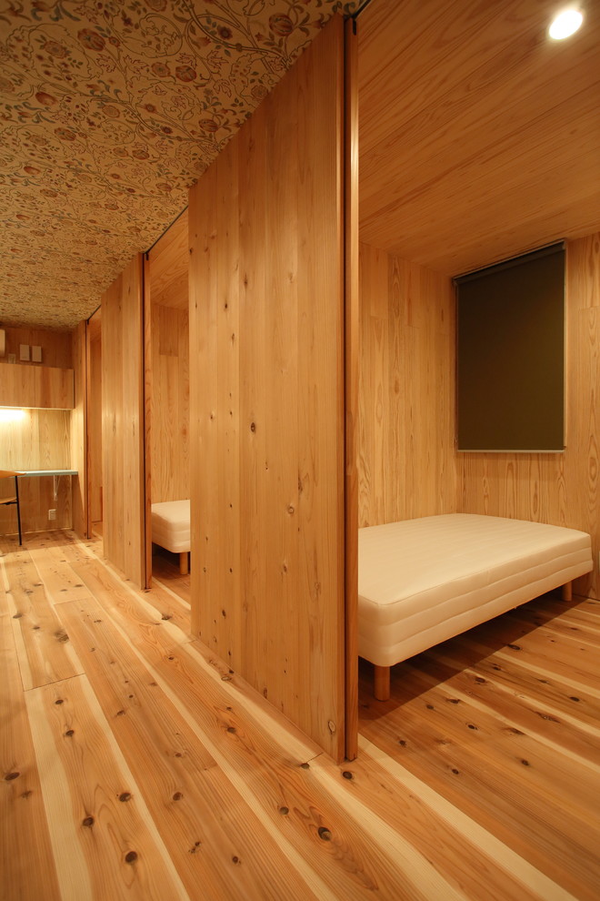 Esempio di una piccola cameretta per bambini da 4 a 10 anni moderna con pareti beige, pavimento in legno massello medio e pavimento marrone