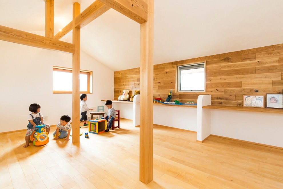 Imagen de habitación infantil unisex asiática con paredes blancas y suelo de madera en tonos medios