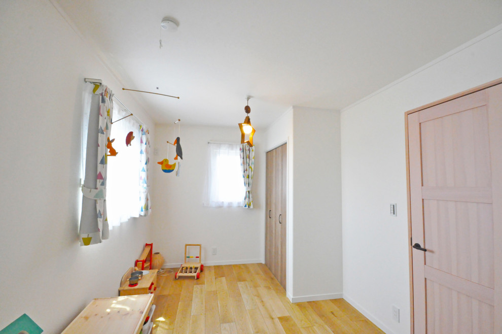 Idéer för könsneutrala småbarnsrum kombinerat med lekrum, med vita väggar, plywoodgolv och brunt golv