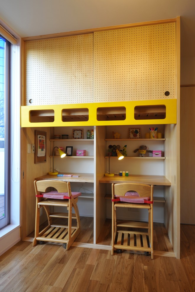 Exempel på ett litet modernt barnrum kombinerat med skrivbord, med gula väggar, mellanmörkt trägolv och brunt golv