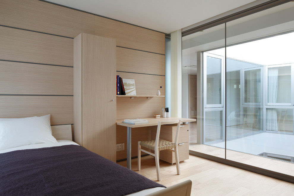 Idéer för ett modernt könsneutralt tonårsrum kombinerat med sovrum, med beige väggar och ljust trägolv