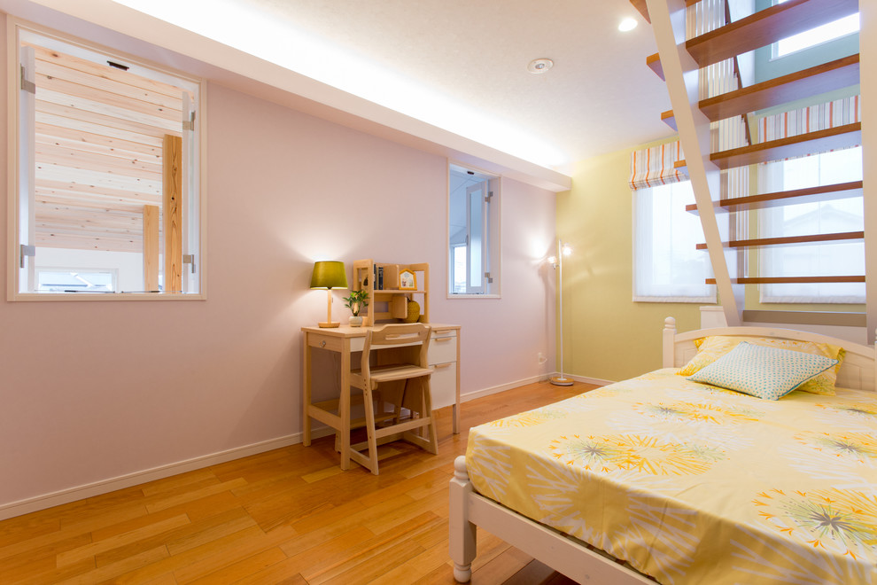 Aménagement d'une chambre de fille de 4 à 10 ans asiatique de taille moyenne avec un bureau, un sol en bois brun et un mur jaune.