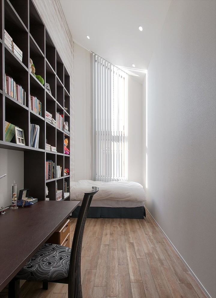 Cette photo montre une chambre d'enfant moderne avec un mur blanc, un sol en bois brun et un sol marron.