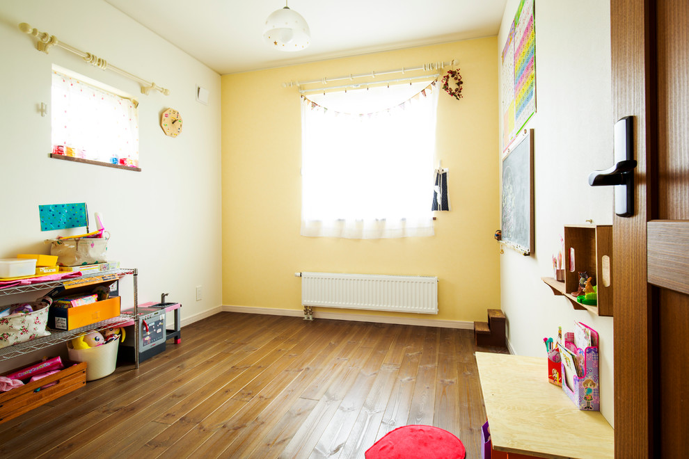 Inspiration för små nordiska barnrum kombinerat med lekrum, med gula väggar och mellanmörkt trägolv