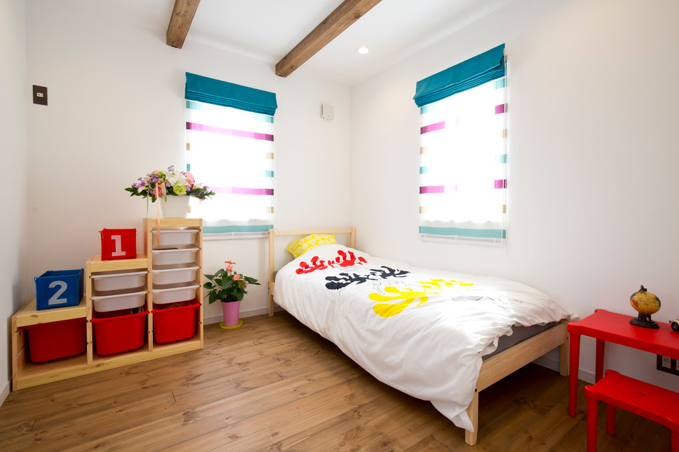 Aménagement d'une chambre d'enfant contemporaine avec un mur blanc, un sol en bois brun et un sol marron.