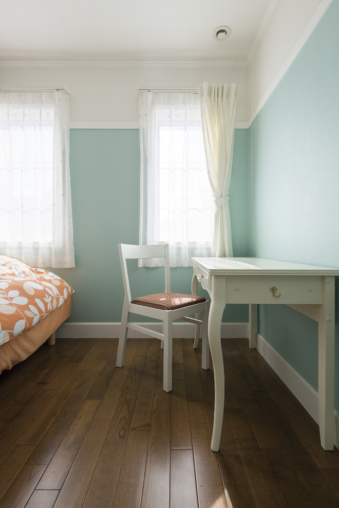 Cette photo montre une petite chambre d'enfant chic avec un bureau, un mur bleu, parquet foncé et un sol marron.