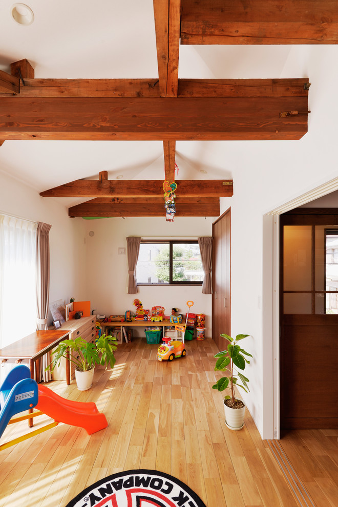 Neutrales Asiatisches Kinderzimmer mit Spielecke, weißer Wandfarbe, braunem Holzboden und braunem Boden in Tokio