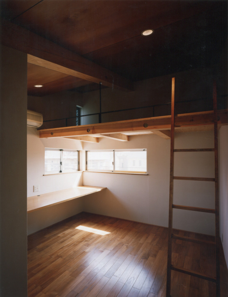 Esempio di una cameretta per bambini da 4 a 10 anni etnica di medie dimensioni con pareti bianche, pavimento in legno massello medio e pavimento marrone