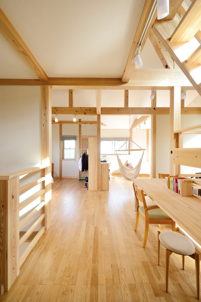 Ejemplo de dormitorio infantil de 4 a 10 años asiático grande con paredes blancas y suelo de madera en tonos medios