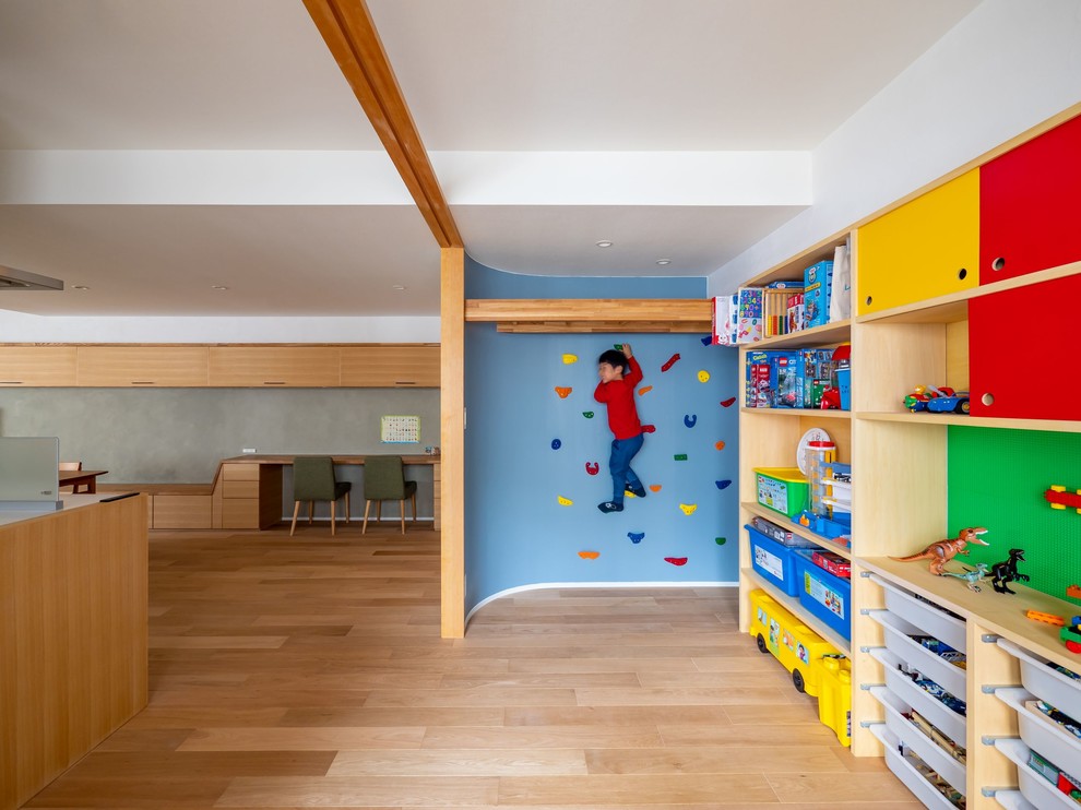 Immagine di un'ampia stanza dei giochi moderna con pareti blu, parquet chiaro e pavimento marrone