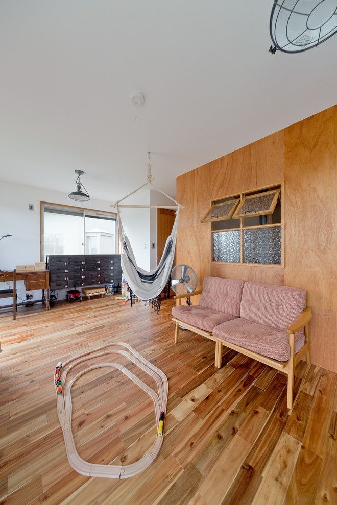 Imagen de dormitorio infantil de 1 a 3 años urbano de tamaño medio con paredes blancas, suelo de madera en tonos medios y suelo marrón