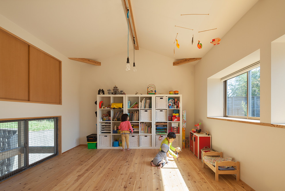 World-inspired gender neutral kids' bedroom in Other with light hardwood flooring and white walls.