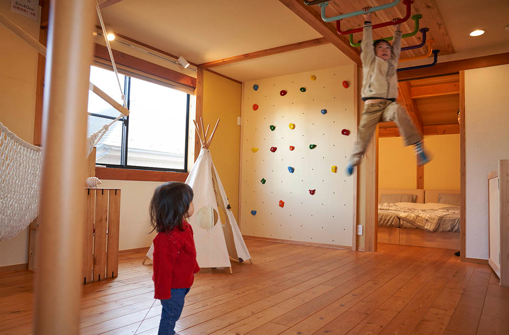 Foto di una cameretta per bambini etnica con pareti bianche, pavimento in legno massello medio e pavimento marrone