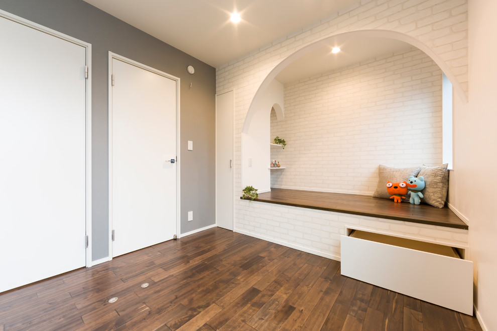 Aménagement d'une chambre d'enfant moderne avec un mur gris, parquet foncé et un sol marron.