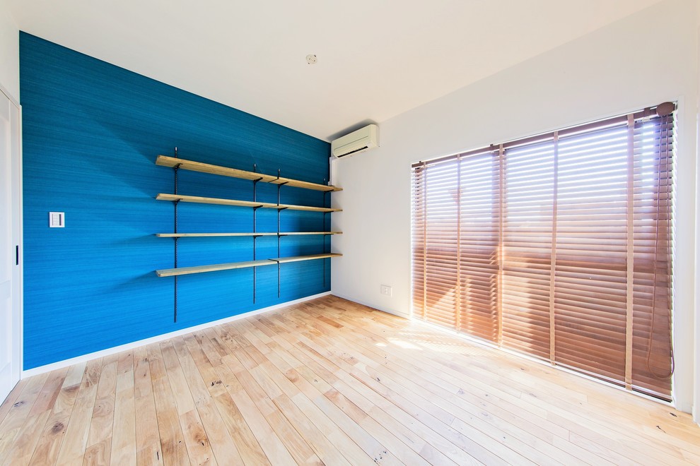 Idées déco pour une chambre d'enfant industrielle de taille moyenne avec un mur bleu et parquet clair.